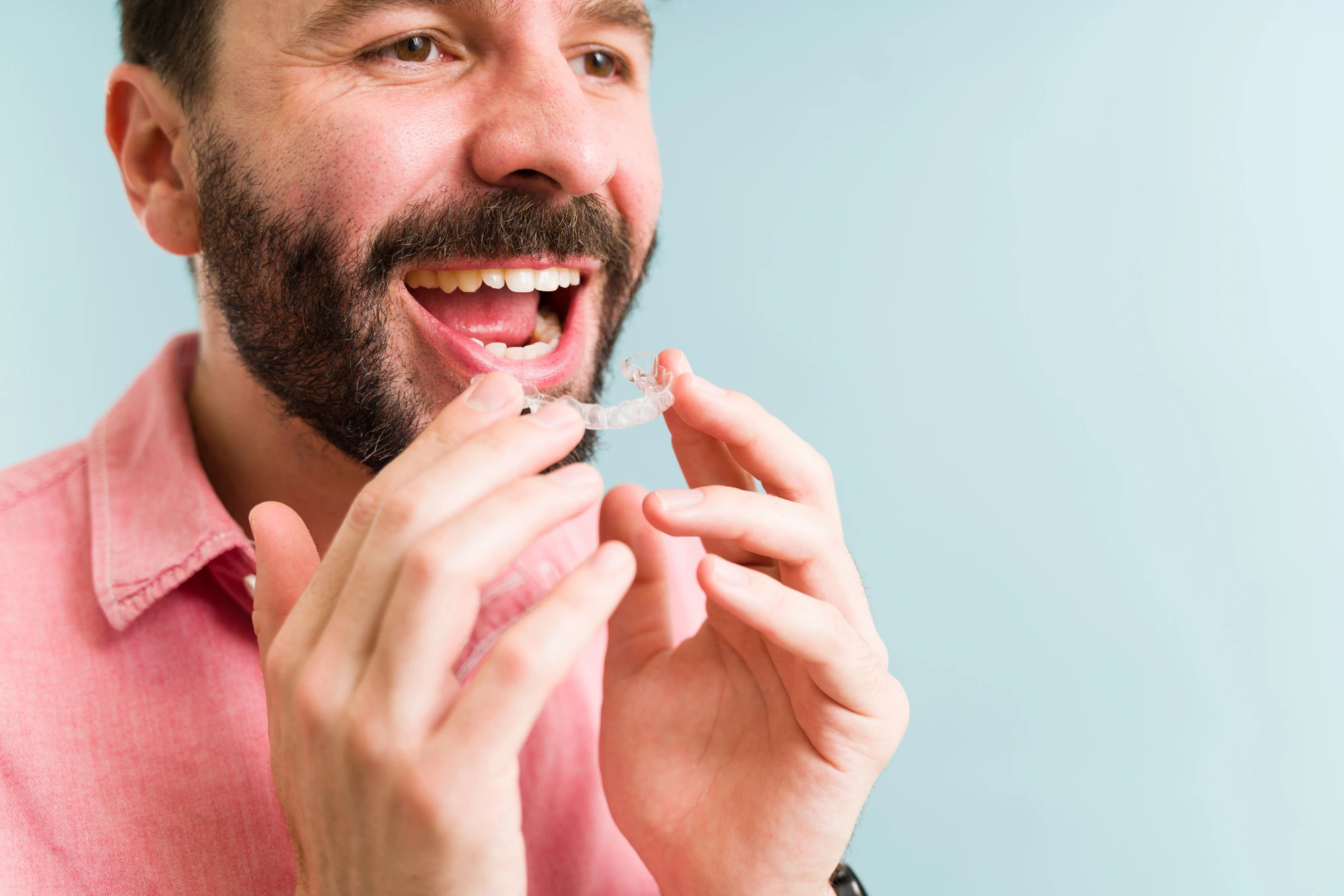 man putting on Invisalign in Dilworth, NC