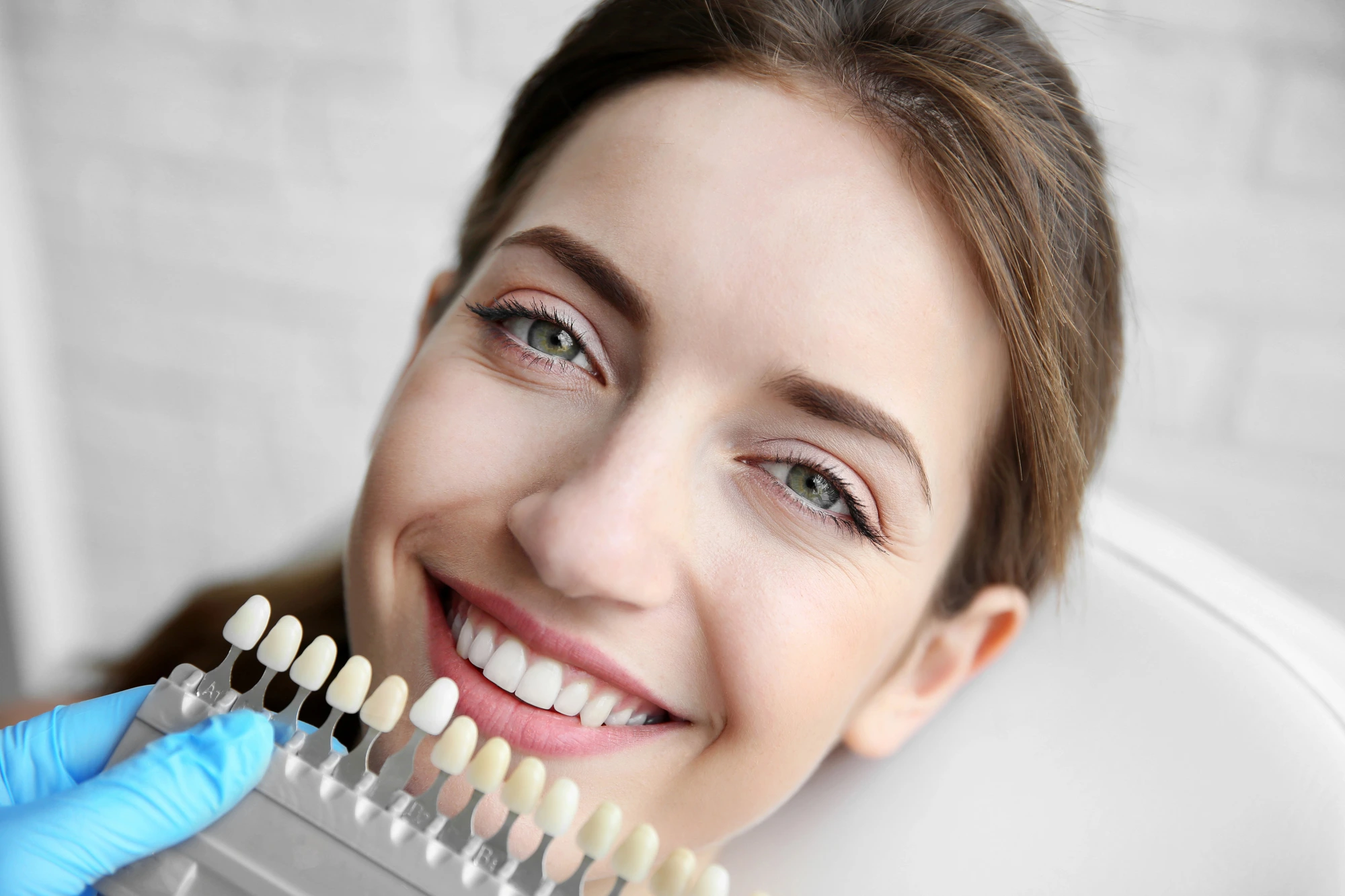 woman at the dentist comparing tooth colors before teeth whitening in South End Charlotte