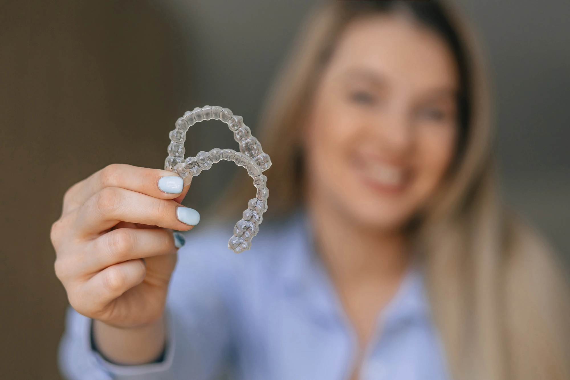 woman holding Invisalign in Uptown Charlotte