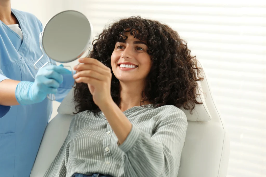 woman looking at herself after cosmetic dentistry in Uptown Charlotte (1)